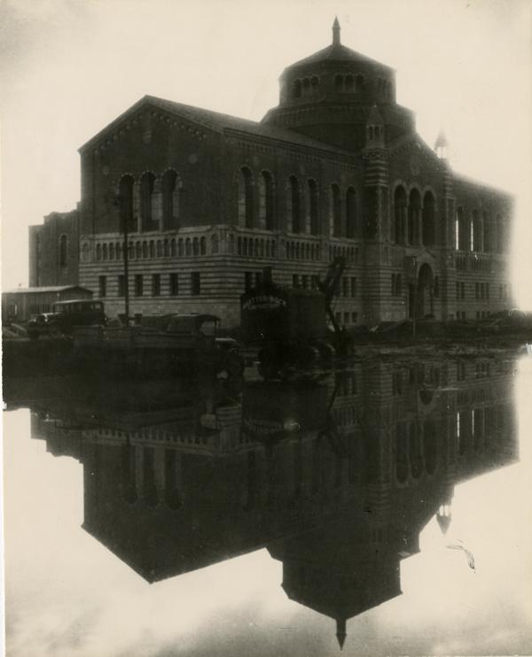 Powell Library and a reflecting pool formed from Winter rains, ca. December 1928