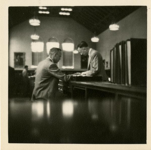 Richard O'Brien at the Reference Desk helping patron, 1949