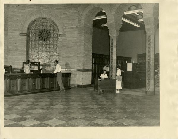 Library staff assisting patrons of the Powell Library