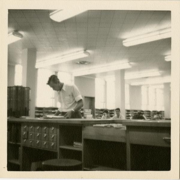 Jim Mink at reference desk in the Periodicals Room at Powell Library, 1949