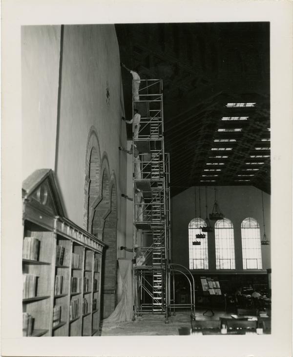 Workers painting the interior of Powell Library