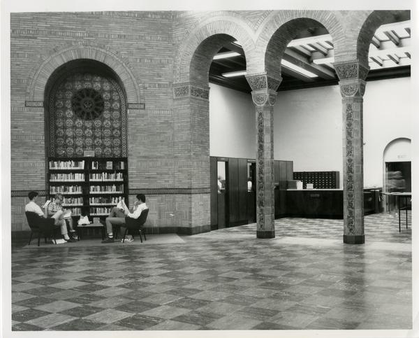 Students sitting in front of small library stack
