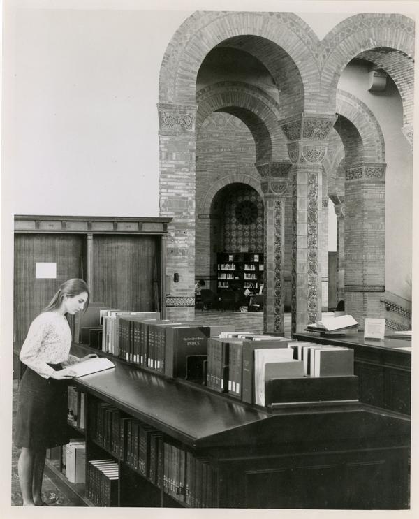 Student looking at a book in Powell Library