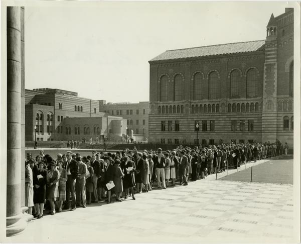 Powell Library in background as students stand in line to register for classes, February 1930