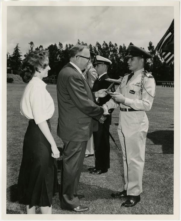 Chancellor Raymond B. Allen presents the Lockhead Aircraft 104-B Starfighter model to Cadet Lieutenant Colonel Bernard Katzman, Air Force ROTC at the annual review of the UCLA ROTC, May 2, 1957