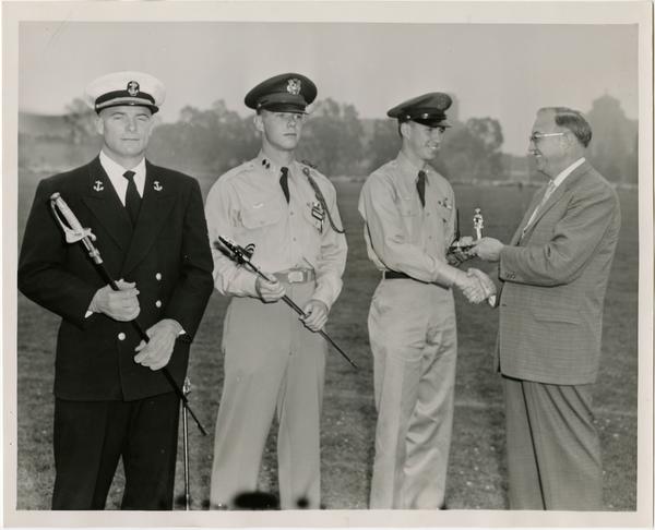 Chancellor Raymond B. Allen congratulating cadets, ca. 1956