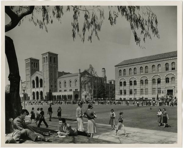 Northwest view of Royce Hall and Haines Hall as students walk and sit in main quadrangle between classes