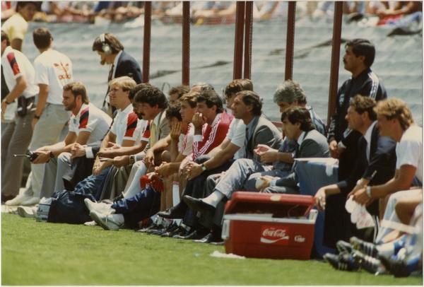 UCLA team member, Paul Caligiuri, sitting on sideline with teammates at 1986 FIFA World Cup All-Star Game , July 1986