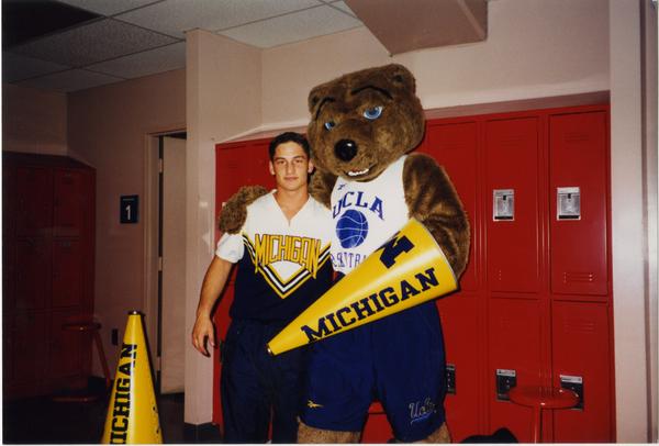 Joe Bruin with member of Michigan Spirit Squad in locker room, ca. March 1998