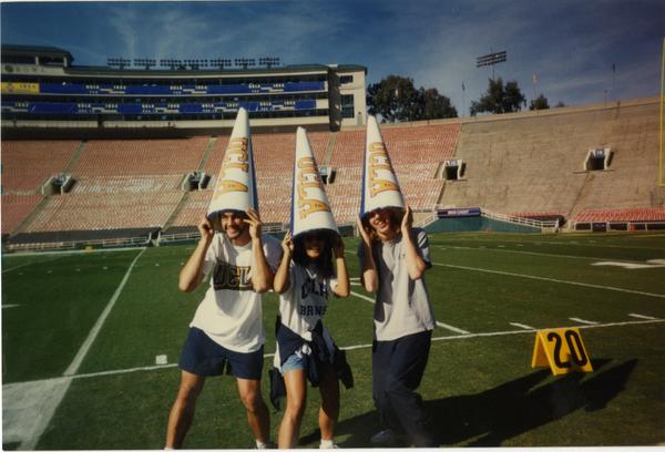 Members of Spirit Squad posing on field with megaphones on heads