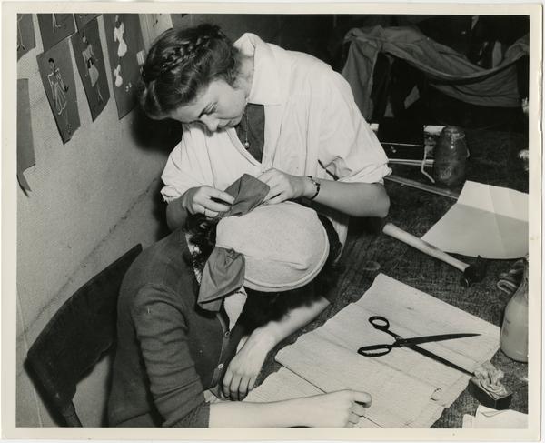 Students constructing a hat to be used in a play in "Green Room" of Theater Arts Department