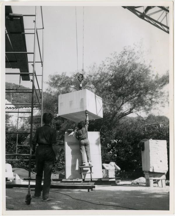 Installation of limestone column for Anna Mahler's scultpture with her back to camera