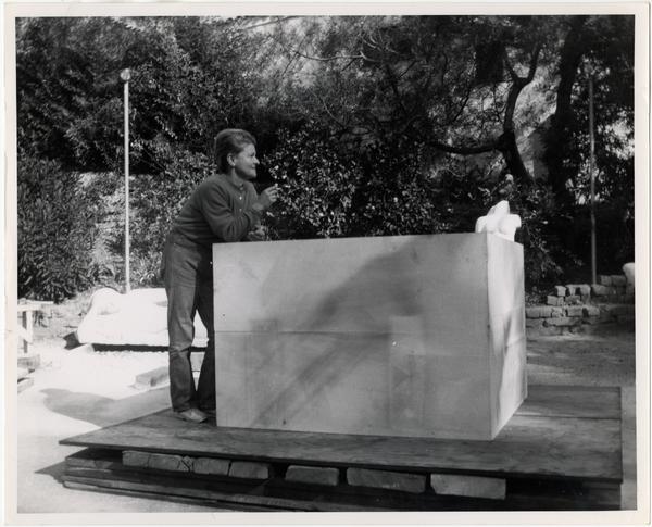 Anna Mahler standing beside limestone block during installation of column
