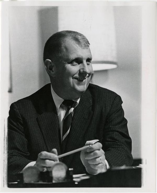 Doug Kinsey sitting at desk with pencil in hand