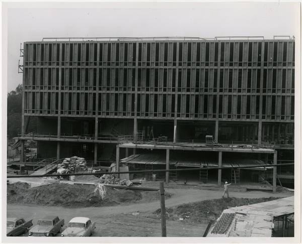 Construction worker walking in front of construction of the University Research Library