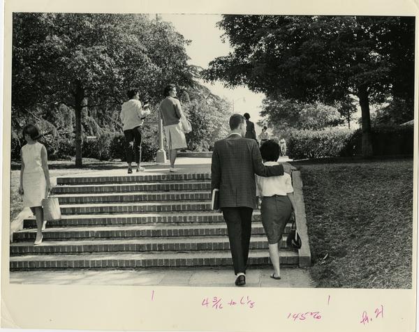 Students walking up stairs on campus, ca. 1964
