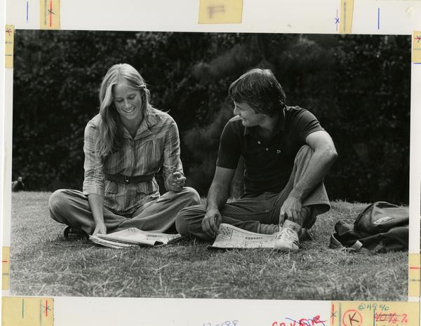 Student couple sitting on grass, ca. 1980's