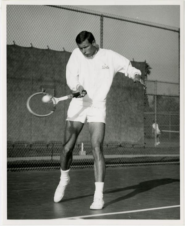 UCLA tennis team member, Dave Reed, hitting ball with raquet