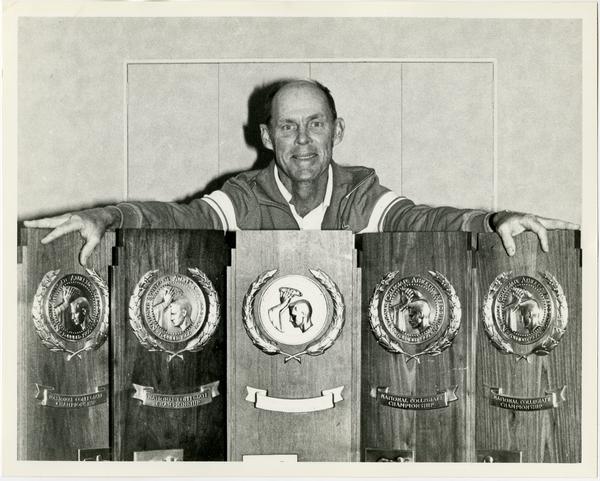 Coach holding NCAA awards, ca. 1982