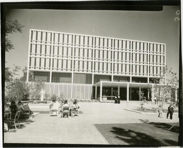 Students sitting at tables in front of the University Research Library