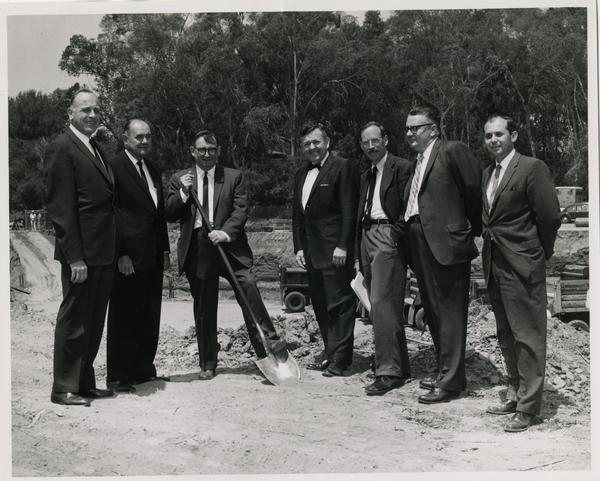 William G. Young, Robert Vosper and others posing on the site of the new University Research Library during the groundbreaking ceremony