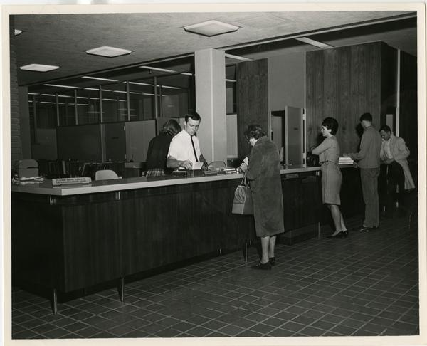 Patrons at the reference desk at the University Research Library, ca. 1964
