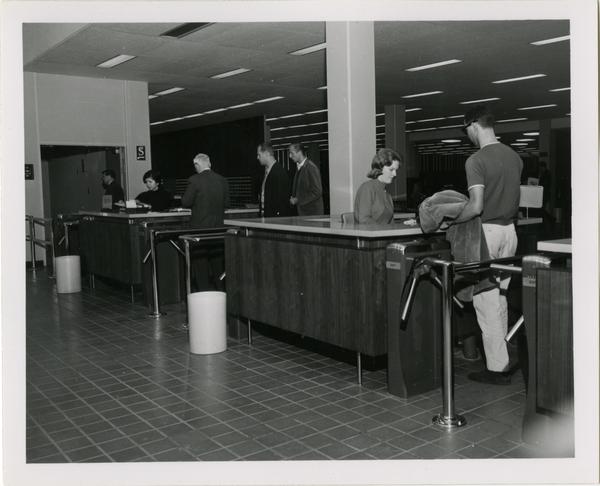 Patrons checking out materials and exiting University Research Library, ca. 1964
