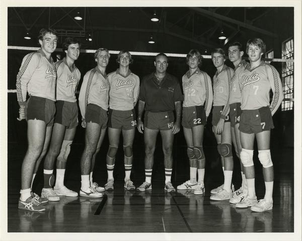 Men's volleyball team posing with coach
