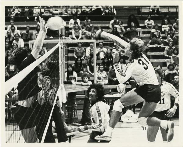UCLA volleyball team player mid shot during game