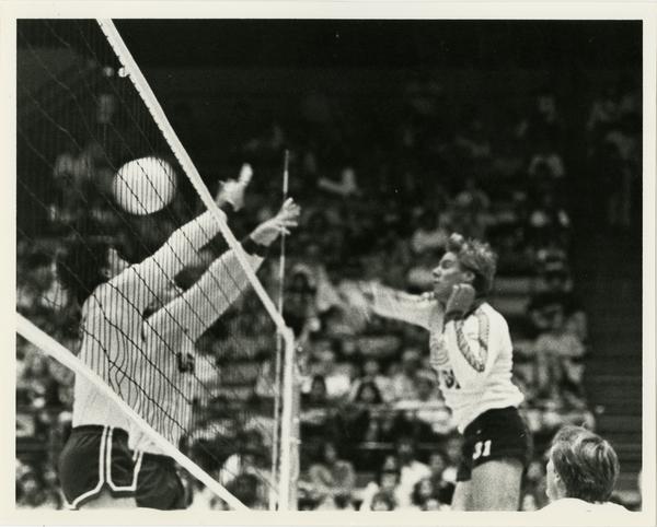 UCLA volleyball team player spiking the ball during a game