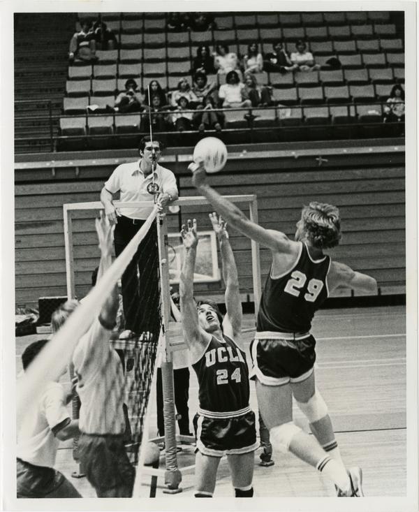 UCLA volleyball player setting the ball for teammate during a game