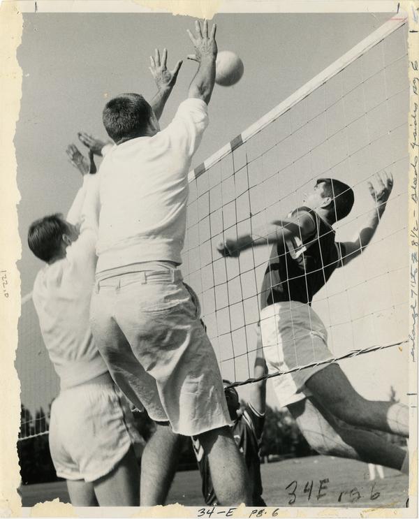 Volleyball player spiking the ball over the net during Intramural game