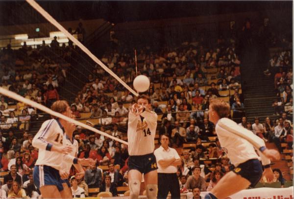 UCLA volleyball player setting the ball for teammate during a game, 1983