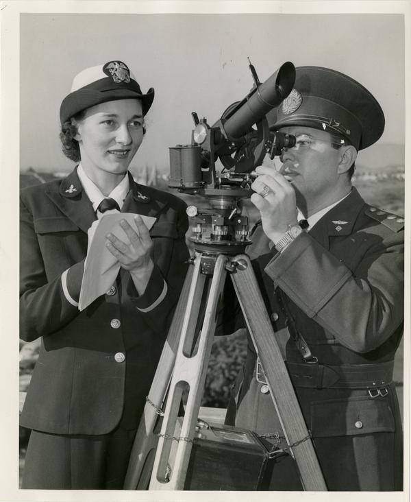 Wave Ensign Helen Alber and Capt. Luis Maria Riviere of the Argentine Air Force take a reading on a theodolite, an instrument used for checking the flight of weather ballons