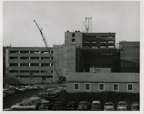 UCLA medical center closer to the finishing of construction with cars parked in the parking lot, 1959