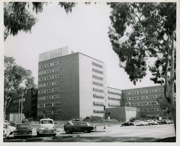 A finished UCLA medical center with a parking lot full of cars, 1960