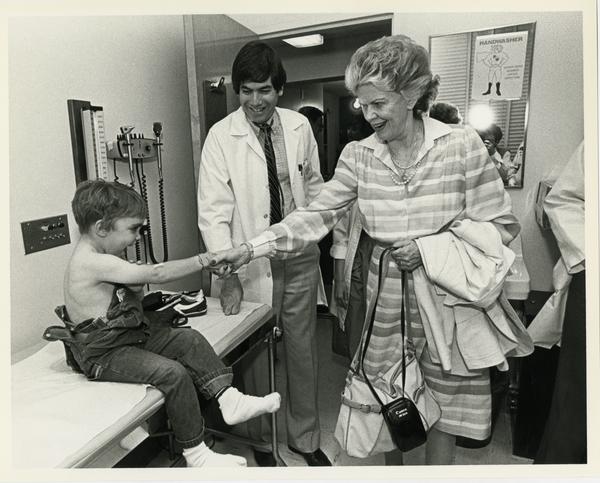 Pediatrician at the medical center examines a small boy, c. 1985