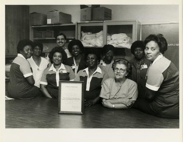 Workers in the medical center central services and supplies office pose for a group photo