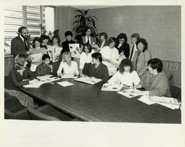 Medi-sence editorial board examine printed publications for a group photo, February 1985