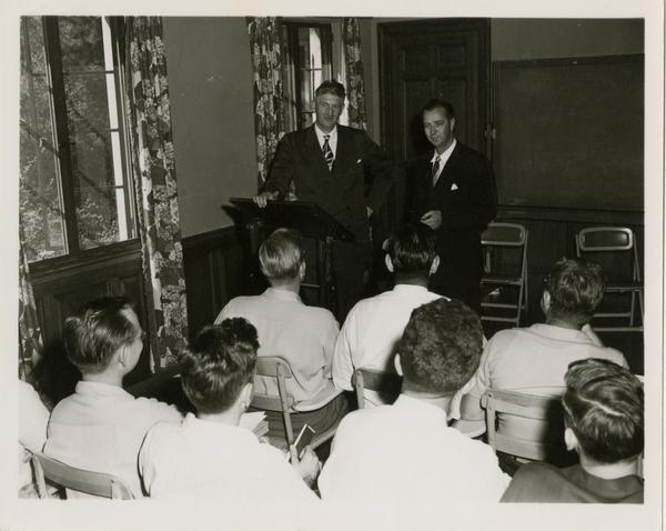 Two men address a crowd of medical school students, 1955
