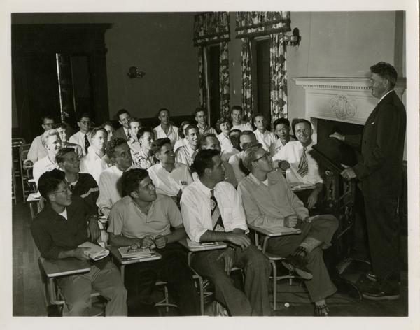 Medical school students listen to a lecturer at the podium, 1955