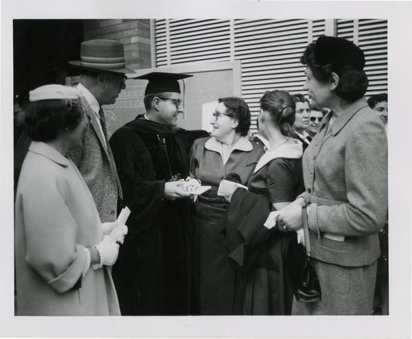 Graduate student of the medical school greets his family after the ceremony, 1956