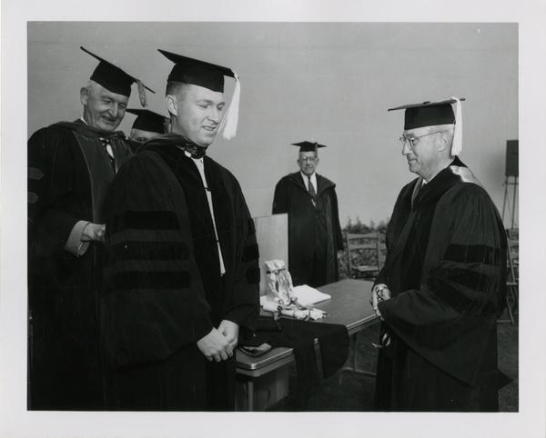 Graduate student accepts his diploma at the ceremony, 1956