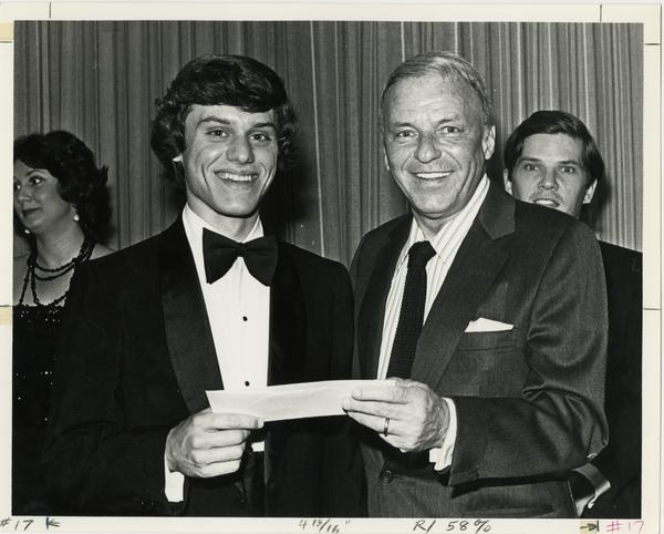 Frank Sinatra and an opera student holding an announcement card at an award ceremony