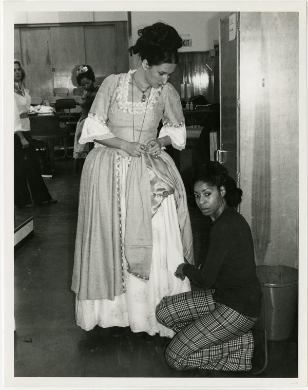 A woman assists an actor with her costume in preparation for Cosi Fan Tutti Opera, 1978