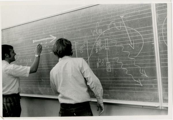 Students writing sheet music on the chalkboard during composition class, 1972