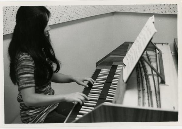 Student plays the piano in the practice room, 1972