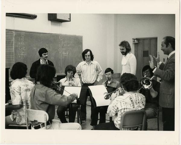Students practice a piece in a circle as instructors look on in composition class, 1975