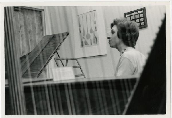 Side view of woman playing a Harpsichord