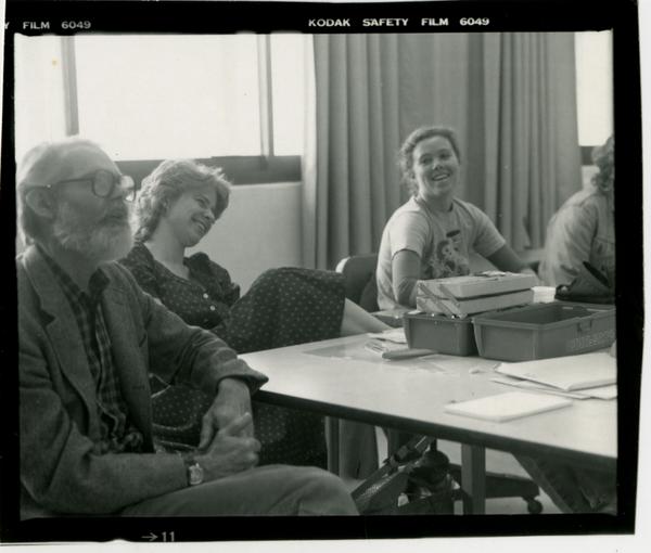 Professor John Neuhard with two students in the background as he lectures the class